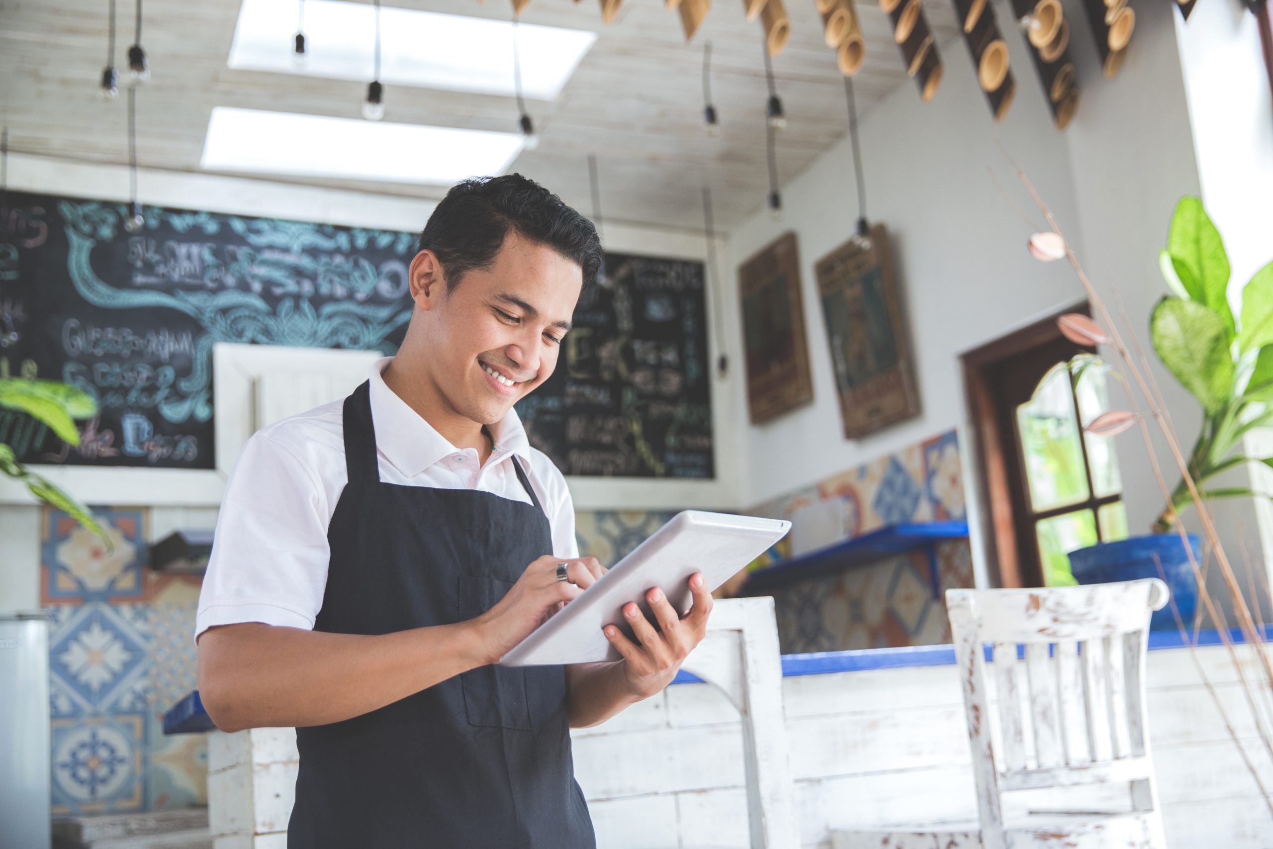 young male cafe owner with tablet