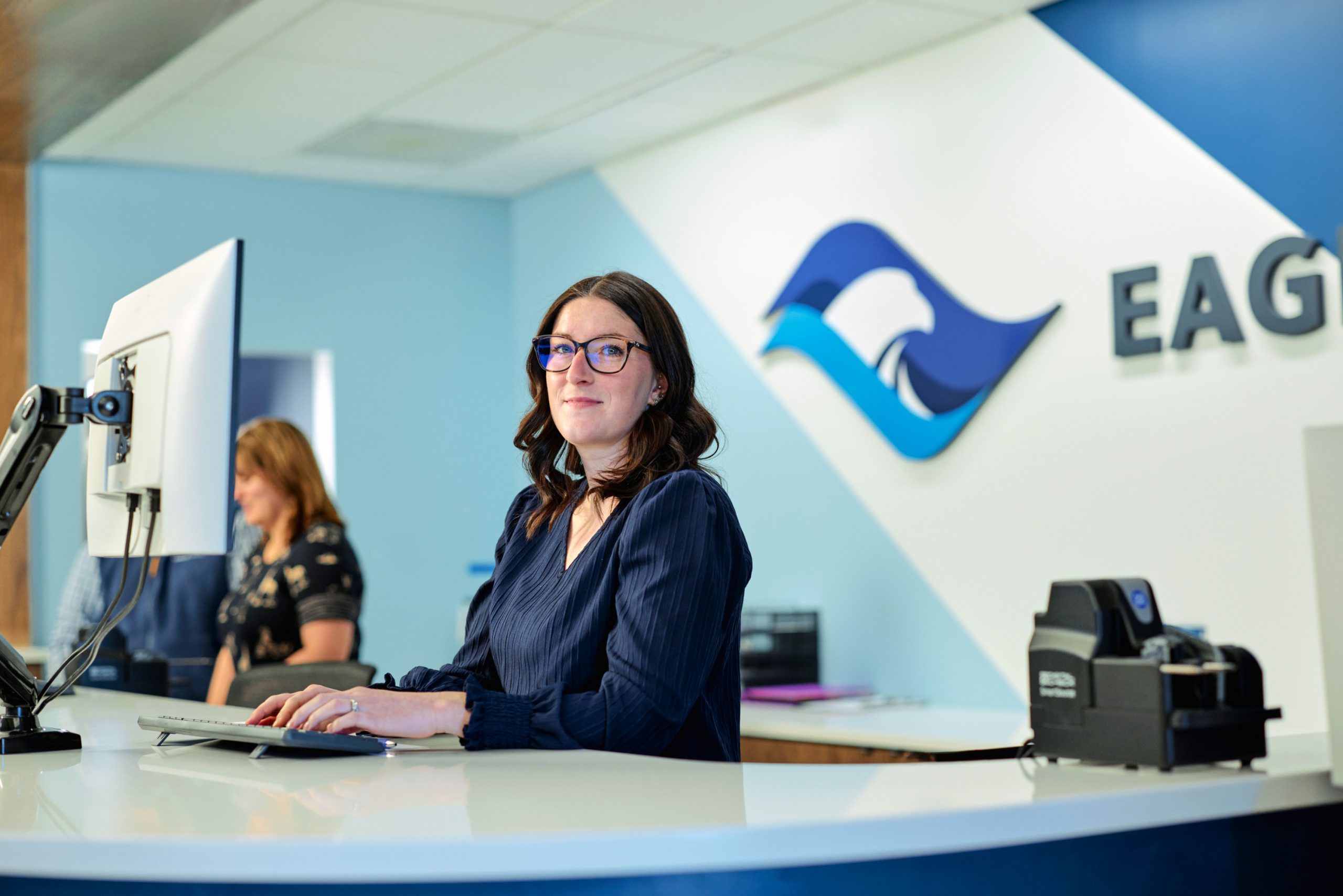 Smiling woman banker sitting at Eagle Bank front desk